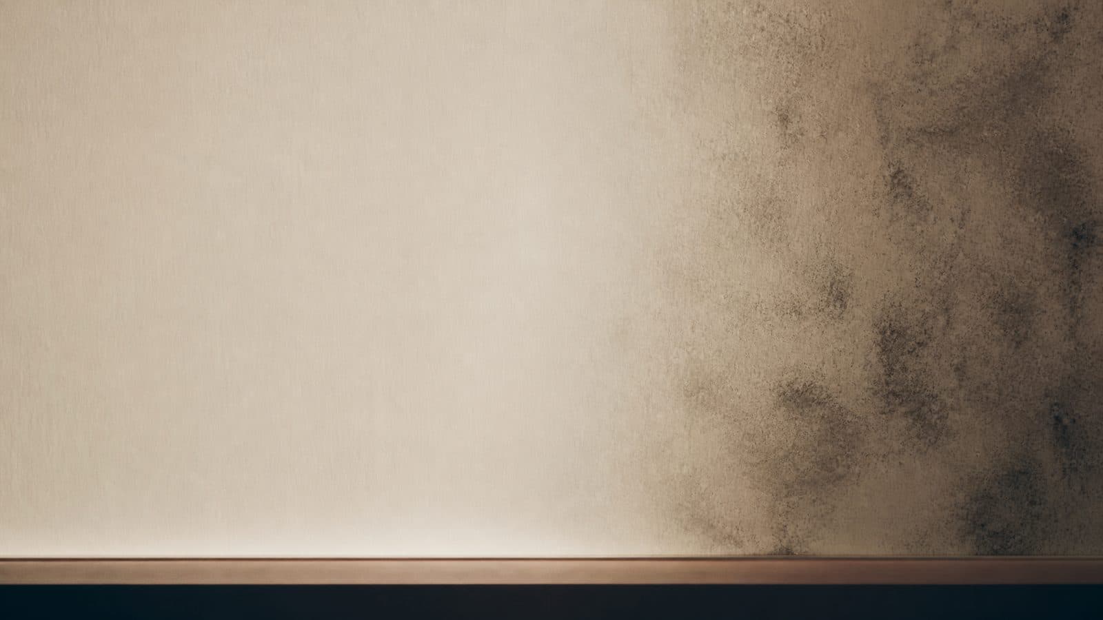 Editorial split-frame comparing a clean section of drywall to a subtly affected section, separated by a soft gradient line.